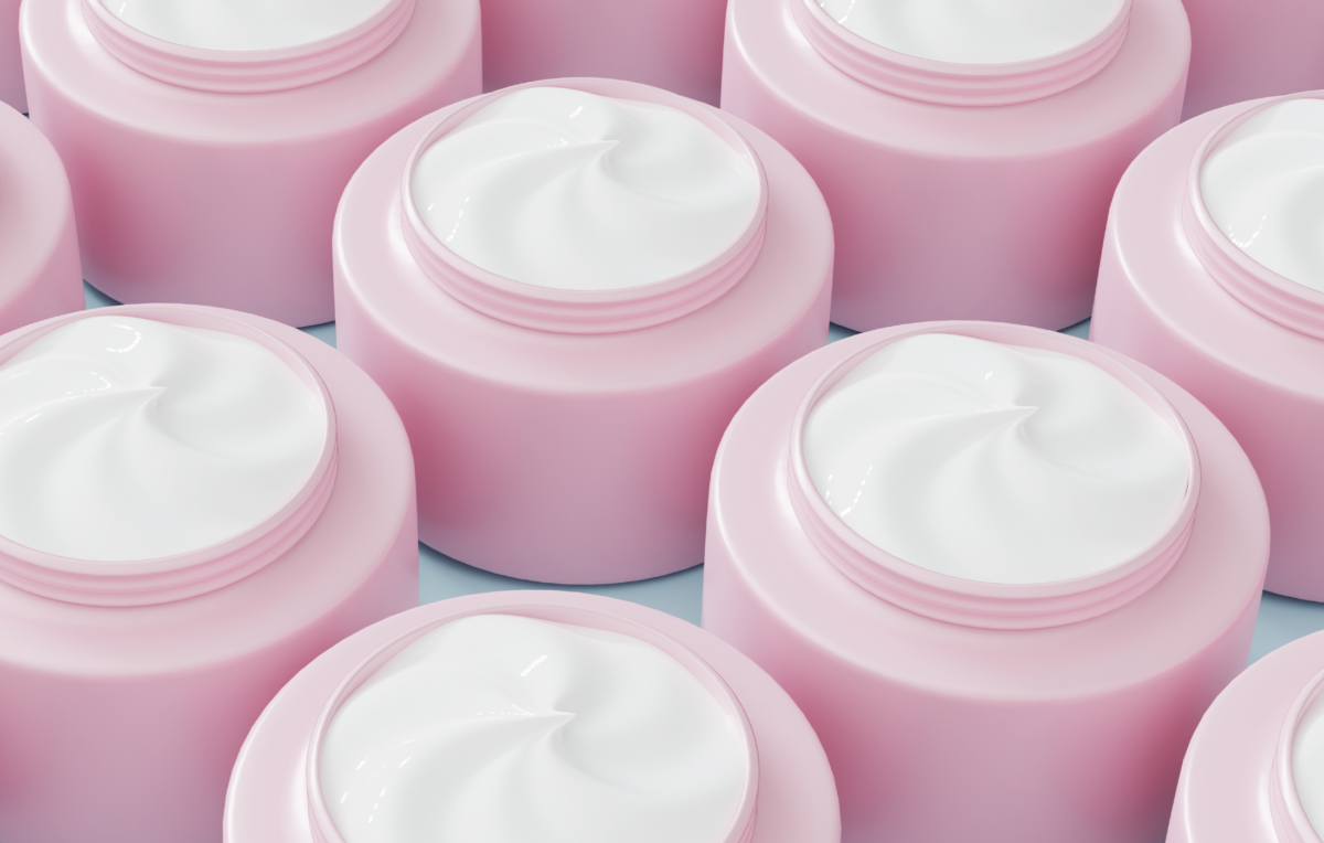 Rows of open pink skin-care jars filled with white cream, shown in close-up