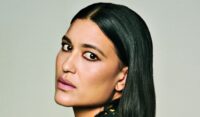 Close-up portrait of Julia Jones with sleek, side-parted black hair, softly smoky eye makeup and muted pink lipstick.